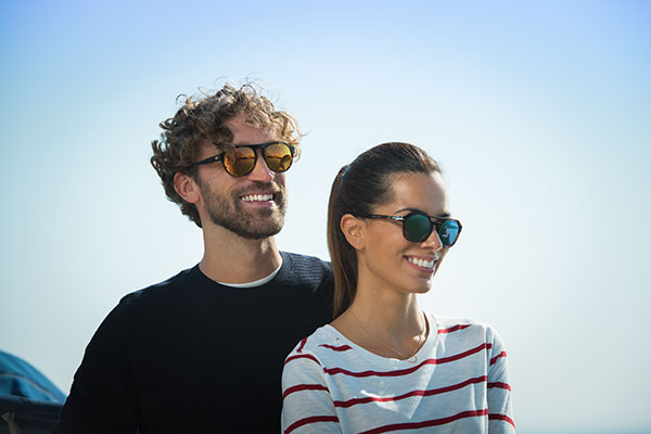 Couple wearing Xperio Mirrored lenses stood on a boat