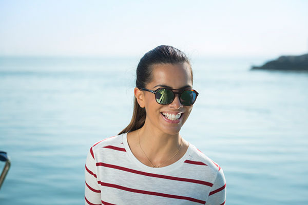 Woman wearing polarised lenses stood on boat smiling