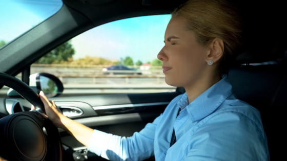 Woman driving closes her eyes to relief eye fatigue caused by staring at same distance